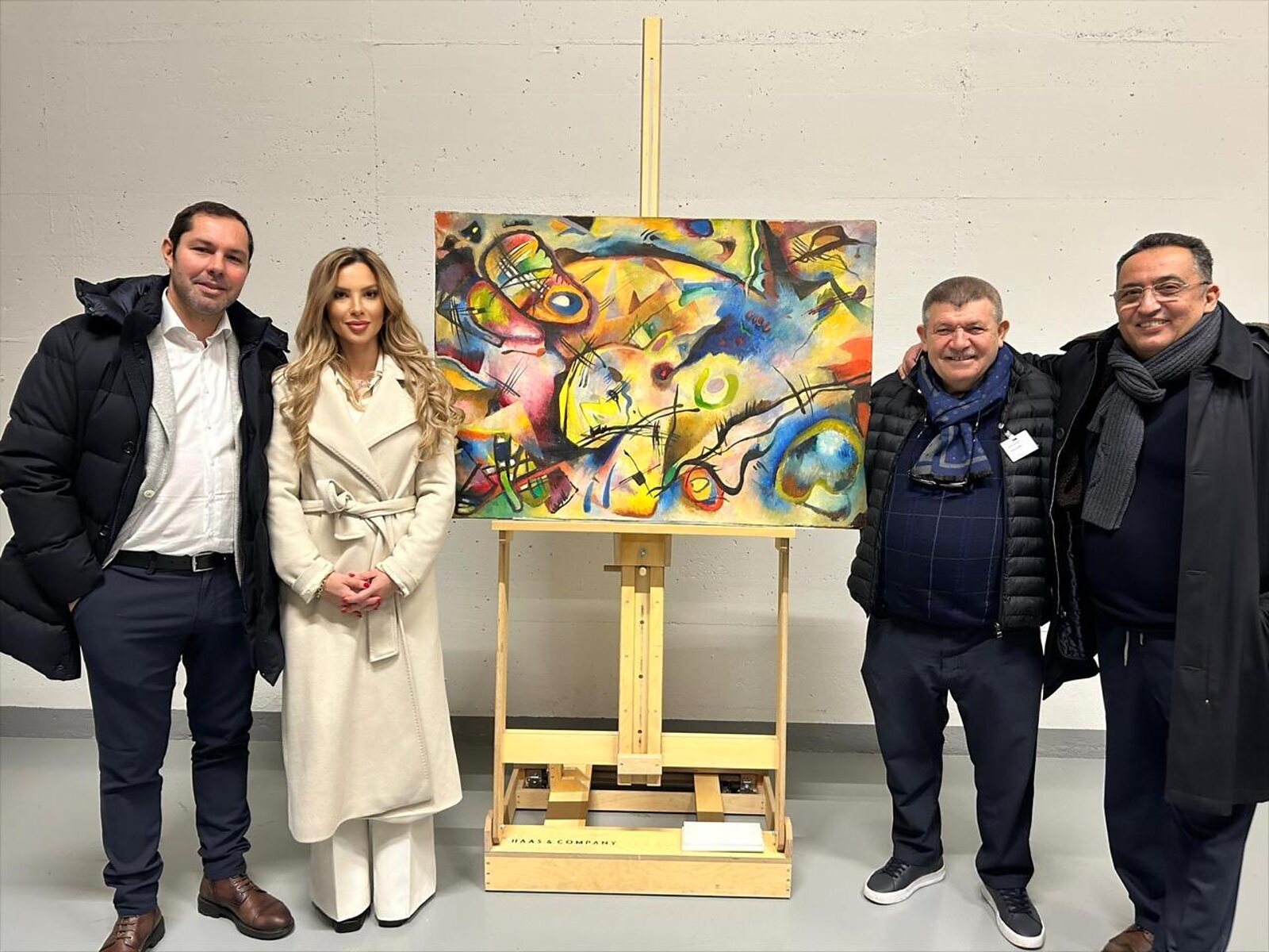 Andranik Ghazarian — Andranik Ghazarian with visitors beside a modern painting placed on the easel at Fine Art International Switzerland.